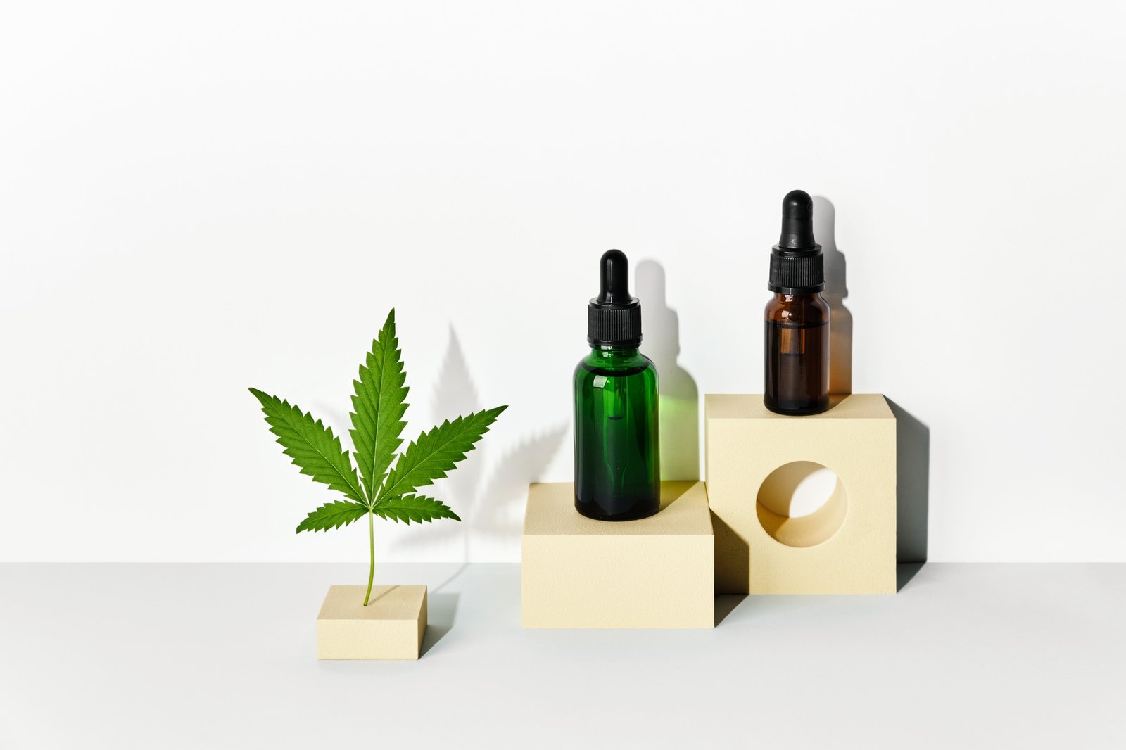 Cosmetic products with CBD oil and hemp extract. Glass bottles and hemp leaf